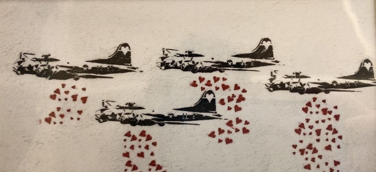 Ein Graffiti zeigt Bombenflugzeuge, die Herzen abwerfen