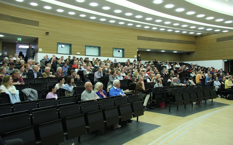 Über 300 Personen, immatrikuliert von den 1950ern bis zu den 2020ern, kamen zu Beginn im Hörsaal 9 zusammen (Foto: Leon Meckler).