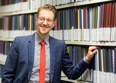 Prof. Dr. Sven Stollfuß ist Experte für digitale Buchkultur, Foto: Swen Reichhold Prof. Dr. Sven Stollfuß vor einem Bücherregal