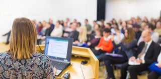 A professor giving a lecture in front of a group of students.