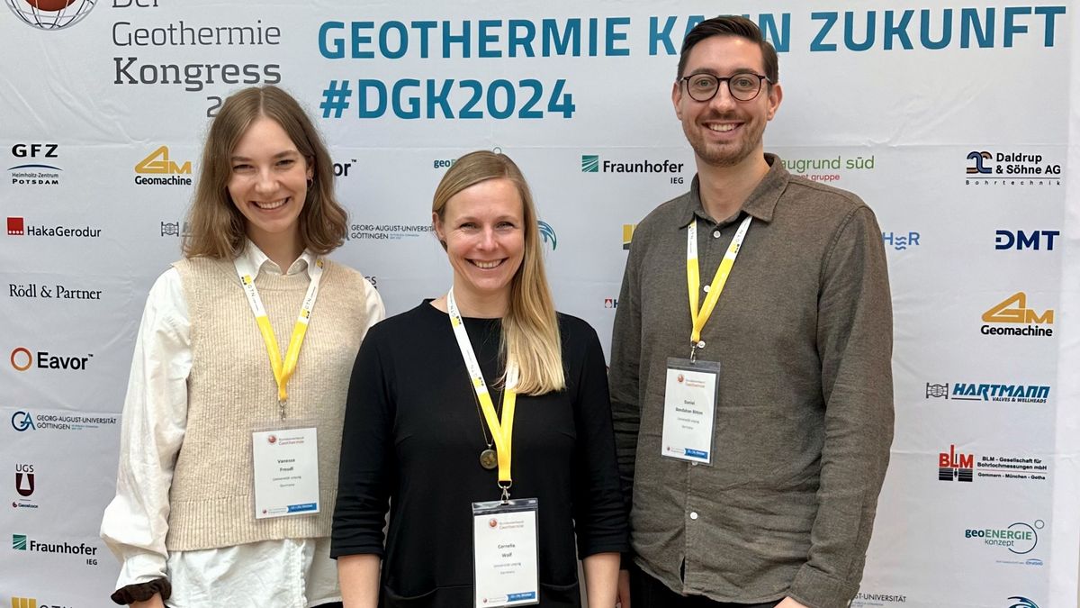 zur Vergrößerungsansicht des Bildes: Auf dem Bild sind Vanessa Freudl, Prof. Dr. Cornelia Wolf und Daniel Bendahan Bitton vor der Sponsorenwand auf dem Geothermiekongress in Potsdam zu sehen.