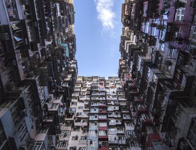 Foto: Blick in den Himmel, eingeschlossen von Hochhausfassaden; das Foto symbolisiert Urbanität