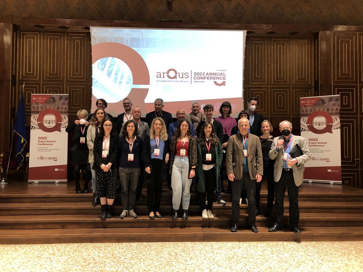 zur Vergrößerungsansicht des Bildes: Gruppenfoto der Vertreter:innen der Universiät Leipzig bei der Arqus Jahresversammlung auf einer Treppe in einem Saal verteilt stehend und in die Kamera lächelnd