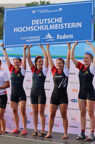 Vier Personen stehen auf dem Siegertreppchen und halten gemeinsam ein Schild vom adh in die Luft.