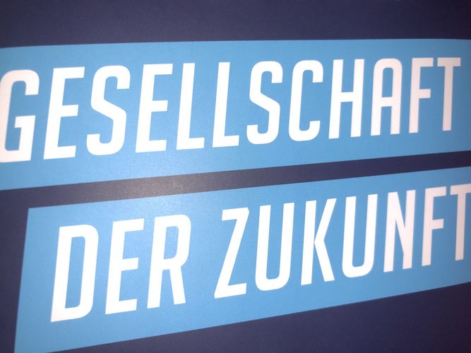 Ausschnitt des Frontcovers, in weißer Schrift himmelblau unterlegt auf dunkelblauem Grund "Gesellschaft der Zukunft", Foto: Jonas Frederik Hartung 
