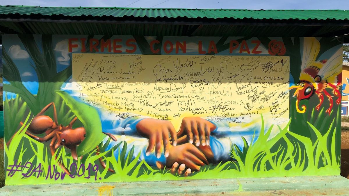 zur Vergrößerungsansicht des Bildes: Eine Wandgemälde zum Friedensprozess zeigt mehrere Hände unter einer Reihe Unterschriften.