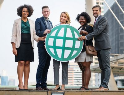 A group of 3 women and 2 men holding an image of the planet.